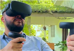 A man holding a remote control and wearing a virtual headset