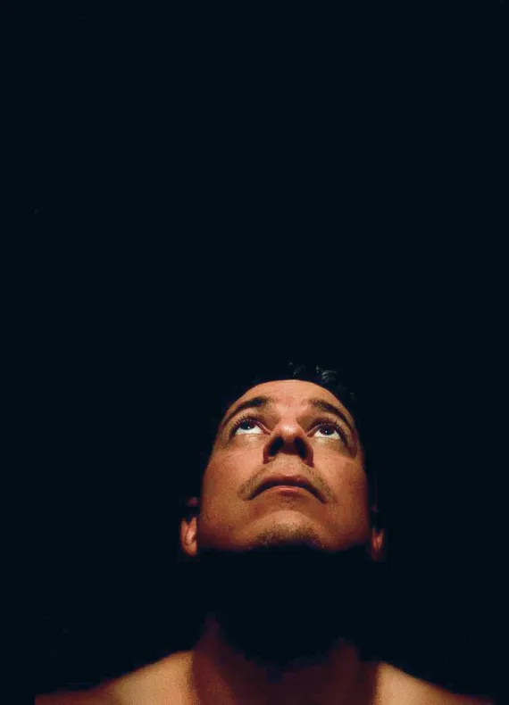 A man looking up at something in the dark