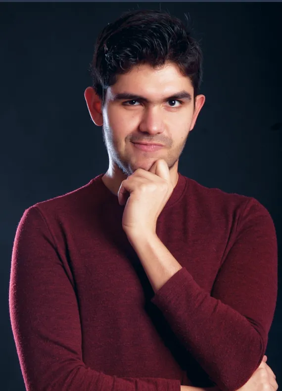 A man in a red sweater posing for a picture